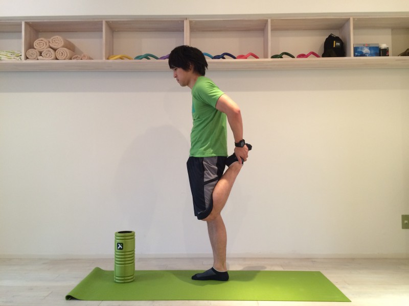 膝の痛みを改善する為外側広筋のストレッチを行なう。外側広筋のストレッチは大腿四頭筋の一般的なストレッチを少し変えたものなので、まずは大腿四頭筋の一般的なストレッチを行なう。大腿四頭筋の一般的なストレッチは腰が反らないように行なうべきであり、腰を反らずに出来ている姿勢を横から見た時の画像